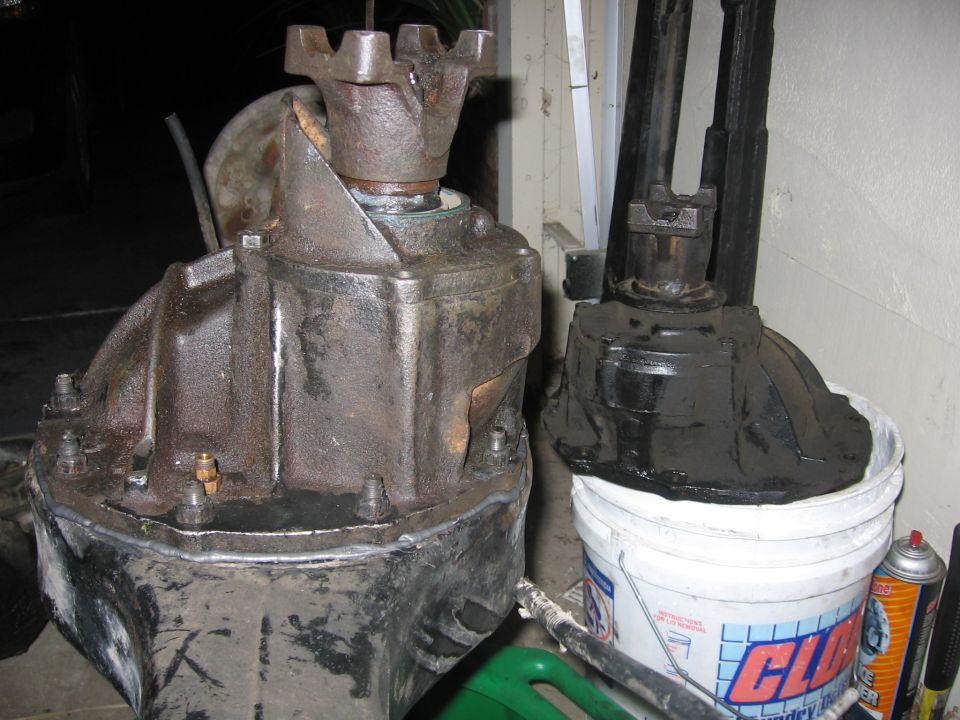 Two cast-iron differential carriers sitting on a garage floor