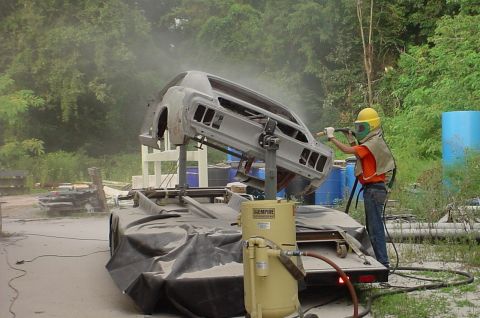 2007 Ford Mustang - Photograph of a car body being blasted on a rotisserie, not a technical document.