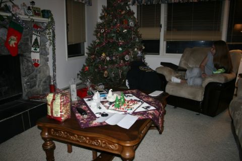 1990 Chevrolet Suburban - A Christmas tree and fireplace decorated for the holidays are in a living room. A person is sitting in a recliner watching something on a l…