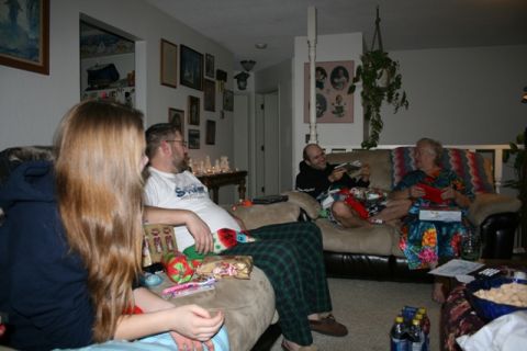 1990 Chevrolet Suburban - A group of people are gathered in a living room, possibly during a holiday celebration. One person is opening a gift while others watch and…