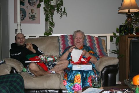 1990 Chevrolet Suburban - A man and an older woman are sitting on a couch in a living room, opening presents.