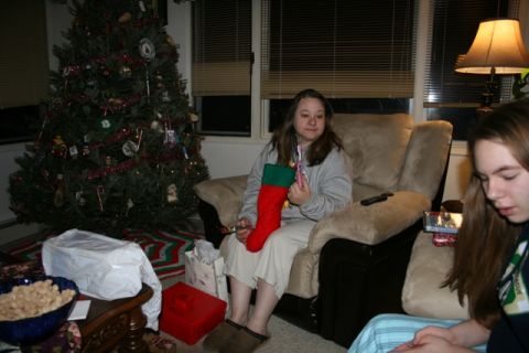 1990 Chevrolet Suburban - A woman sits in a recliner holding a Christmas stocking and a toothbrush, with a decorated Christmas tree in the background.