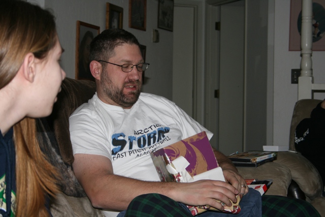 Two people sitting on a couch, one holding a gift.