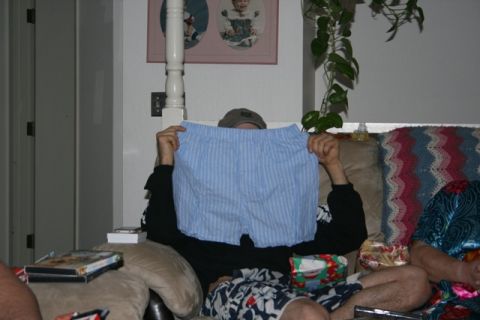 1990 Chevrolet Suburban - A person is holding up a pair of blue striped boxer shorts in front of their face while sitting on a couch. There are DVDs stacked on the c…