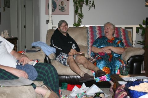 1990 Chevrolet Suburban - Three people are sitting on a couch in a living room. One person on the left is wearing plaid pajama pants and a white t-shirt. The person…
