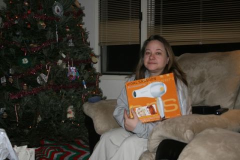 1990 Chevrolet Suburban - A woman sits on a couch holding a Vidal Sassoon hair dryer box next to a decorated Christmas tree.