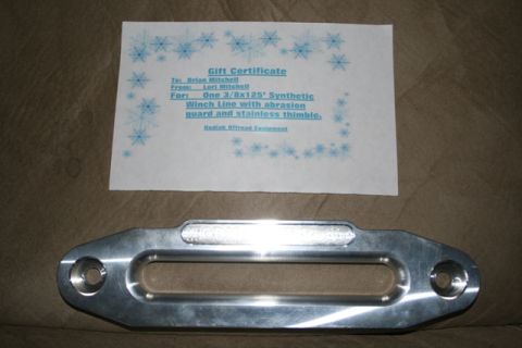 1990 Chevrolet Suburban - A gift certificate for a synthetic winch line is placed above a polished aluminum winch fairlead, likely for an off-road vehicle.