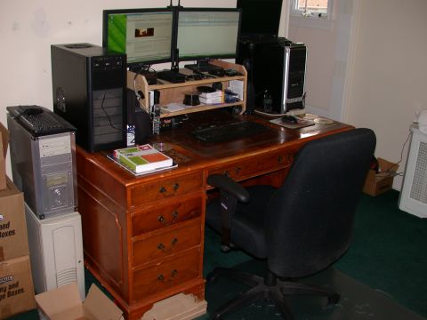 2000 Ford Crown Victoria - A cluttered desk with two computer monitors, computer towers, a keyboard, a mouse, and a black office chair. The desk is made of wood and h…