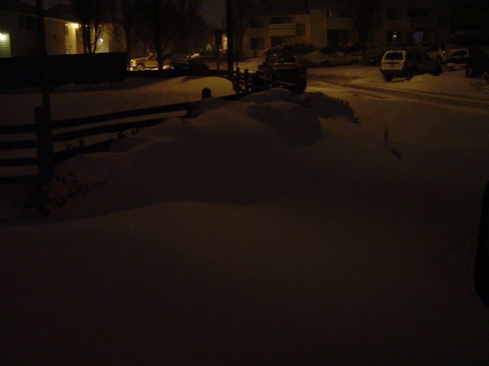 1989 Ford Bronco covered in snow at night
