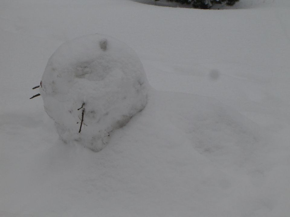 Snowman with stick features in the snow