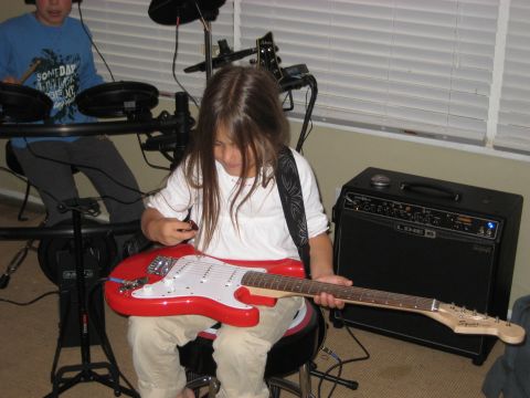 1996 Ford Bronco - Two children are engaged in playing musical instruments, one with a guitar and the other with drums.