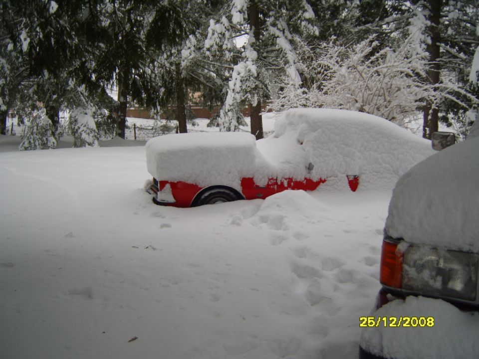 Red vehicle side view buried in snow