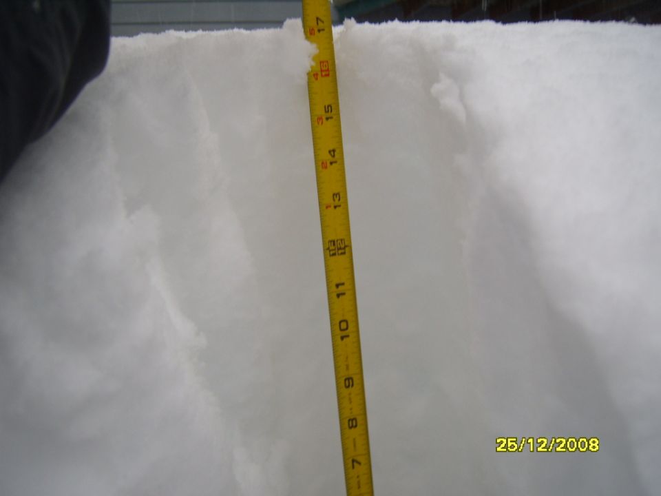 Measuring snow depth with a yellow tape measure. Date stamp shows 25/12/2008