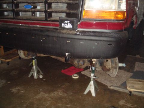 1992 Ford Bronco - Front view of a 1992 Ford Bronco, elevated on jack stands for service, with a Baja Champions sticker on the bumper.