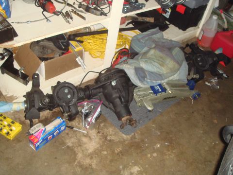 1992 Ford Bronco - Vehicle axles and tools are laid out on the garage floor, possibly for repair or replacement.