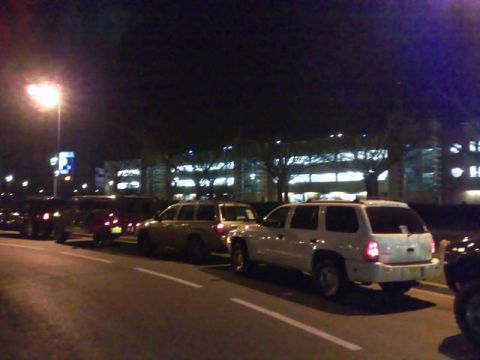 1991 Ford Crown Victoria - Several vehicles are parked along a street at night, with a white SUV in the foreground.