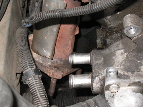 2001 Pontiac Trans Am - Close-up view of an engine component, possibly a thermostat housing, with associated hoses and wiring.