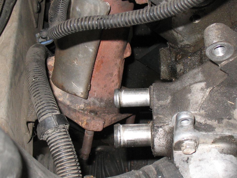 Engine part with two hose connections and metal shielding