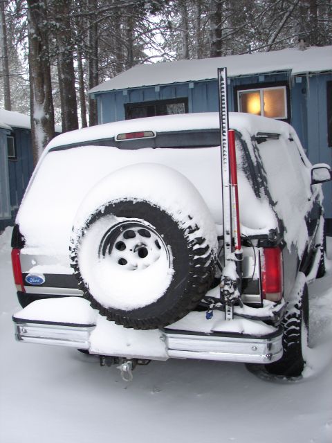 1996 Ford Bronco - Rear view of a 1996 Ford Bronco parked in the snow with a spare tire mounted on the back.
