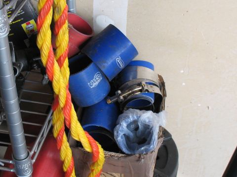 2001 Pontiac Trans Am - A collection of blue silicone hoses and metal clamps are stored in a cardboard box, with a red and yellow rope in the foreground.