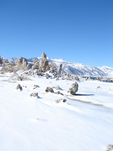 1996 Ford Bronco - Tufa formations stand in a snowy landscape under a clear blue sky with snow-covered mountains in the distance.