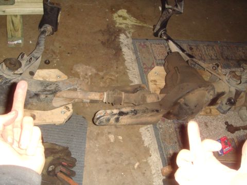 1992 Ford Bronco - Close-up of vehicle suspension parts, with hands making offensive gestures.
