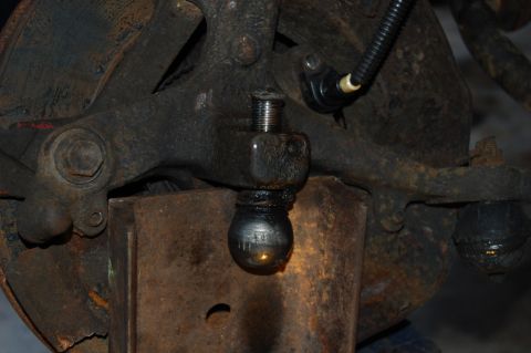 1985 Mercury Grand Marquis - Close-up view of a worn ball joint and associated suspension parts, showing significant rust and grease.
