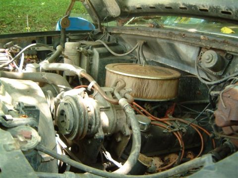 1982 Ford Bronco - The engine bay of a vehicle shows various components, including the air cleaner and hoses.
