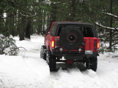 1979 Ford Bronco - Red 1979 Ford Bronco navigates a snow-covered forest road.
