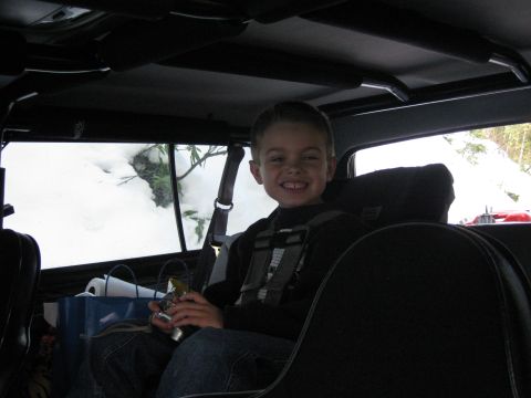 1979 Ford Bronco - A young boy smiles from the interior of a vehicle during a snowy outing.