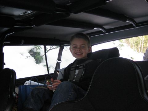 1979 Ford Bronco - A young boy smiles from the back seat of a vehicle, with snow visible outside the window.