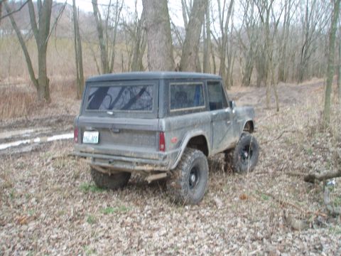 1971 Ford Bronco - This 1971 Ford Bronco is parked in a wooded area with muddy tracks visible.