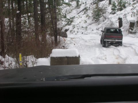 1996 Ford Bronco - A pickup truck navigates a snowy trail, with trees and snow-covered ground visible.