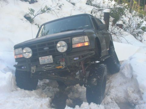 1996 Ford Bronco - This modified Ford Bronco navigates a snowy trail with its lifted suspension and off-road tires.