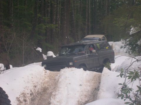 1996 Ford Bronco - Ford Bronco navigates a snowy path in a wooded area, with another vehicle following.