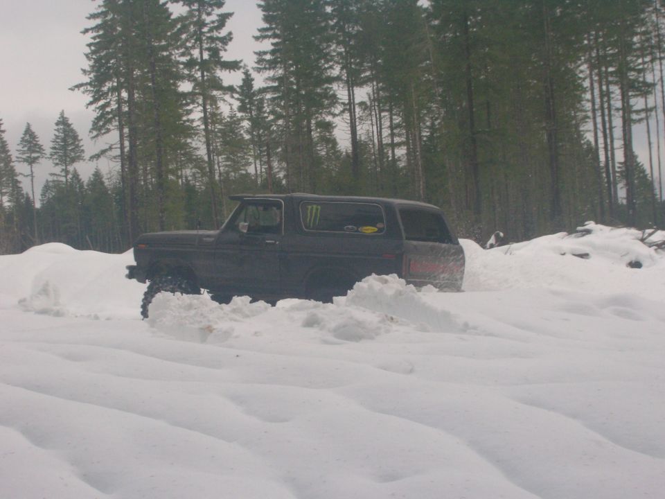 Dark SUV with monster energy sticker driving through deep snow