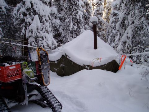 2000 Ford E350 - A snowmobile and camping gear are visible in a snowy forest scene with a tent and trees.