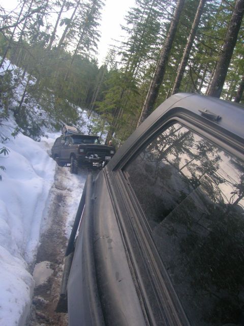 1996 Ford Bronco - Two SUVs navigate a snowy forest road during a winter outing.