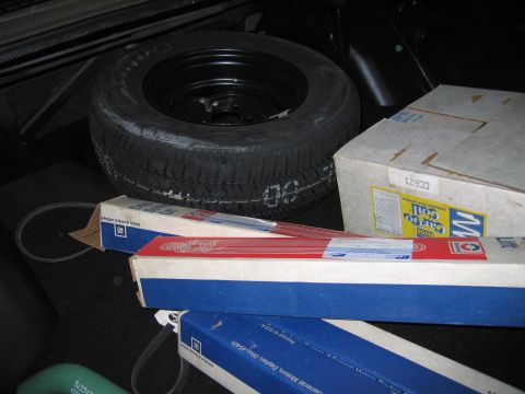 1991 Ford LTD Crown Victoria - Spare tire and boxes of auto parts are visible in the trunk of a vehicle.