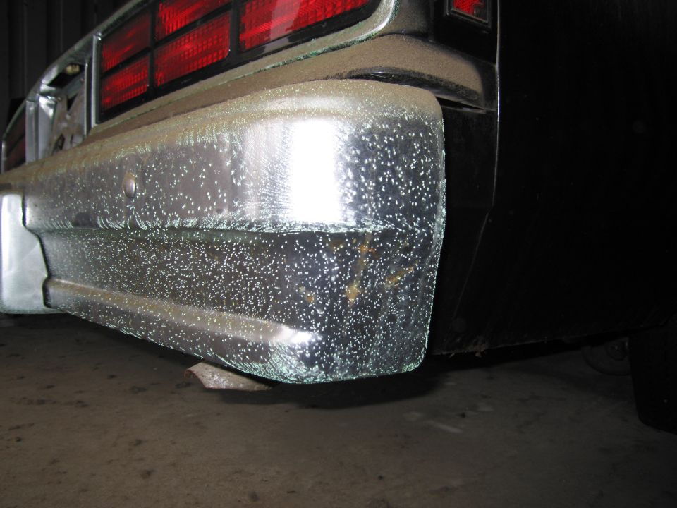 Rear bumper and taillight of a car, covered in small white specks