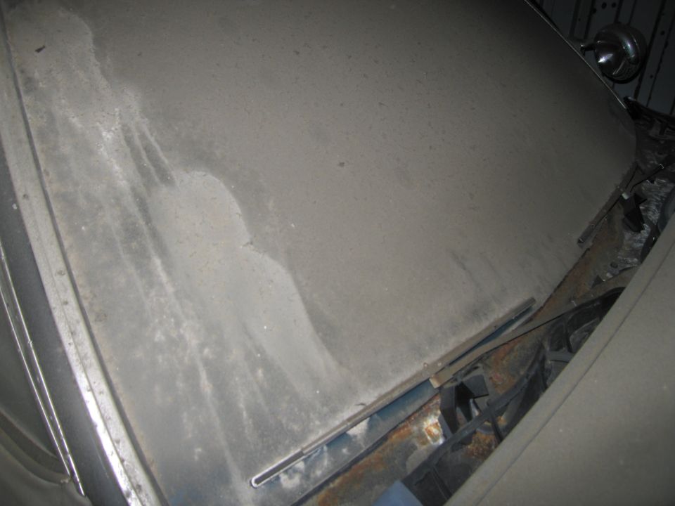 Dusty car hood with water stains and visible rust near the windshield wipers