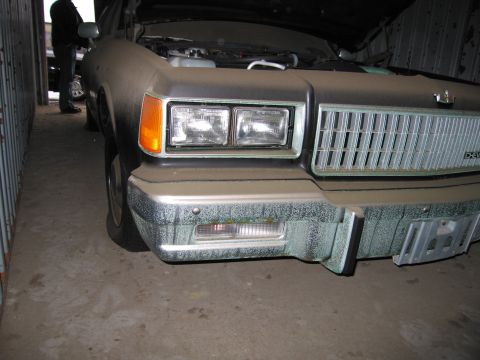 1991 Ford LTD Crown Victoria - The front end of a dusty Chevrolet Caprice, likely from the 1980s, is shown with its hood up.