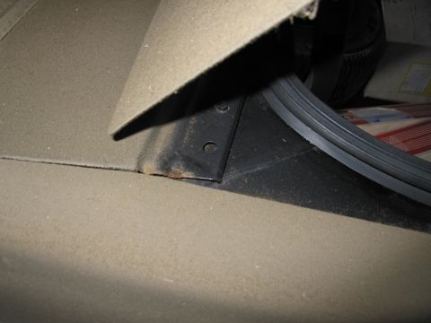 1991 Ford LTD Crown Victoria - Close-up view of the trunk area, showing carpet lining and a metal support bracket.