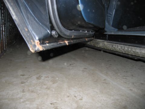 1991 Ford LTD Crown Victoria - Close-up of a rusted door sill, showing signs of wear and tear.