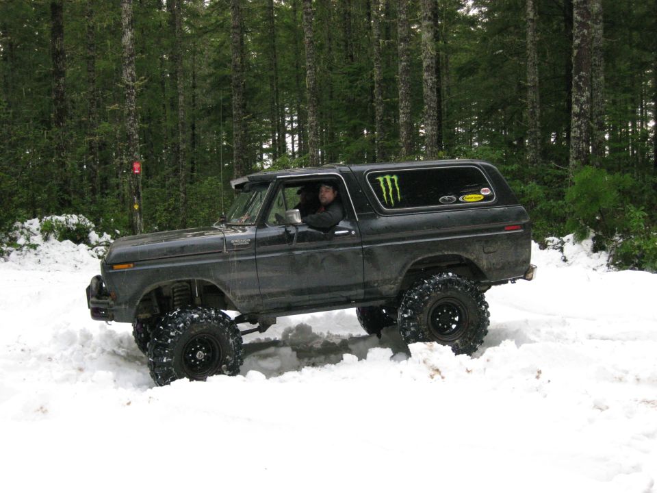 Dark SUV with monster energy sticker in snow, lifted suspension, off-road tires