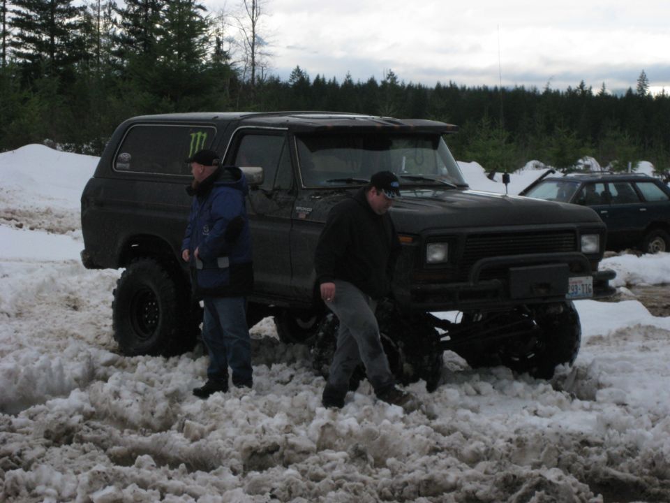 Black 1979 Ford Bronco with lifted suspension in snow, Monster Energy sticker on door