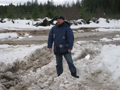 1979 Ford Bronco - A man stands in a snow-covered area with tire tracks visible.