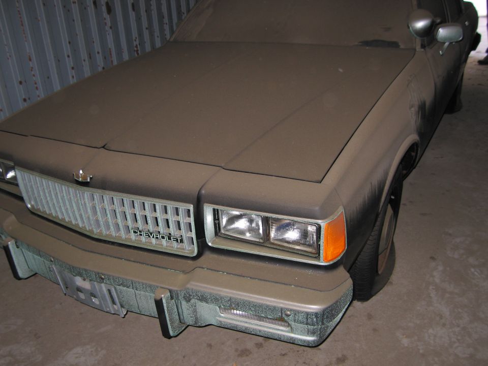 Dusty Chevrolet Caprice front end with chrome grille and "CHEVROLET" badge