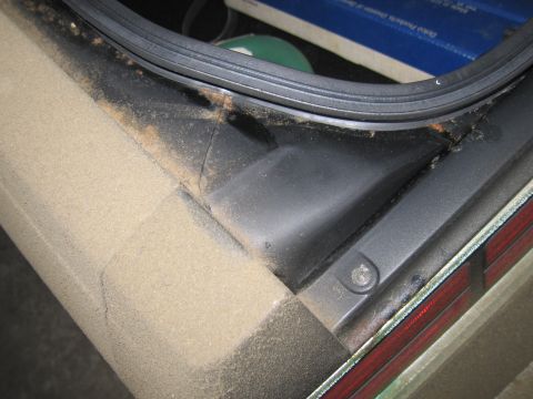 1991 Ford LTD Crown Victoria - Dust and debris have accumulated in the corner of the vehicle's trunk.