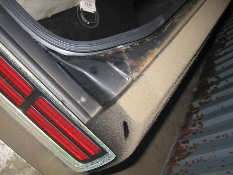1991 Ford LTD Crown Victoria - The trunk sill of a 1991 Ford Crown Victoria LTD shows signs of rust, with a tag reading '7335' visible in the background.